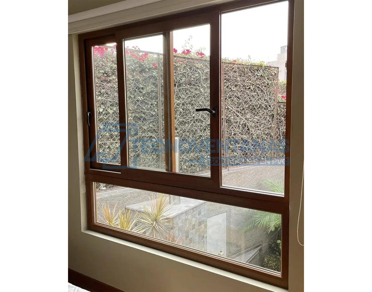 Ventana PVC color madera con vista a jardín